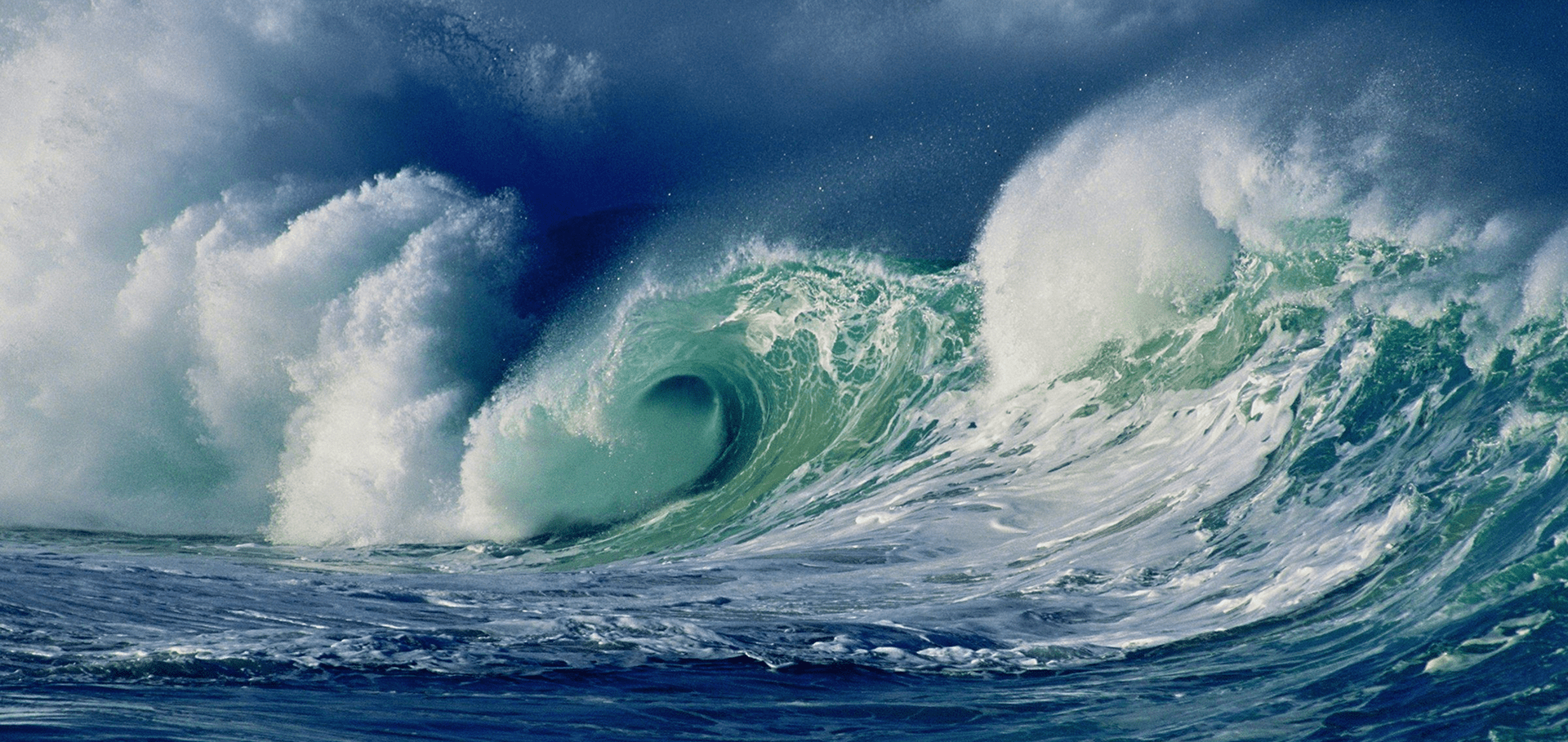 A large wave is crashing on the ocean.