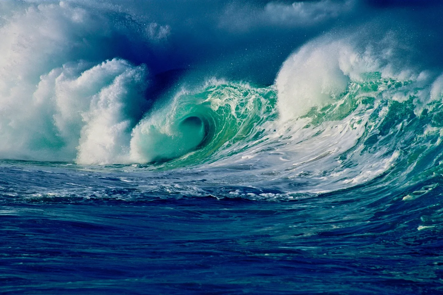 A large wave is crashing on the ocean.